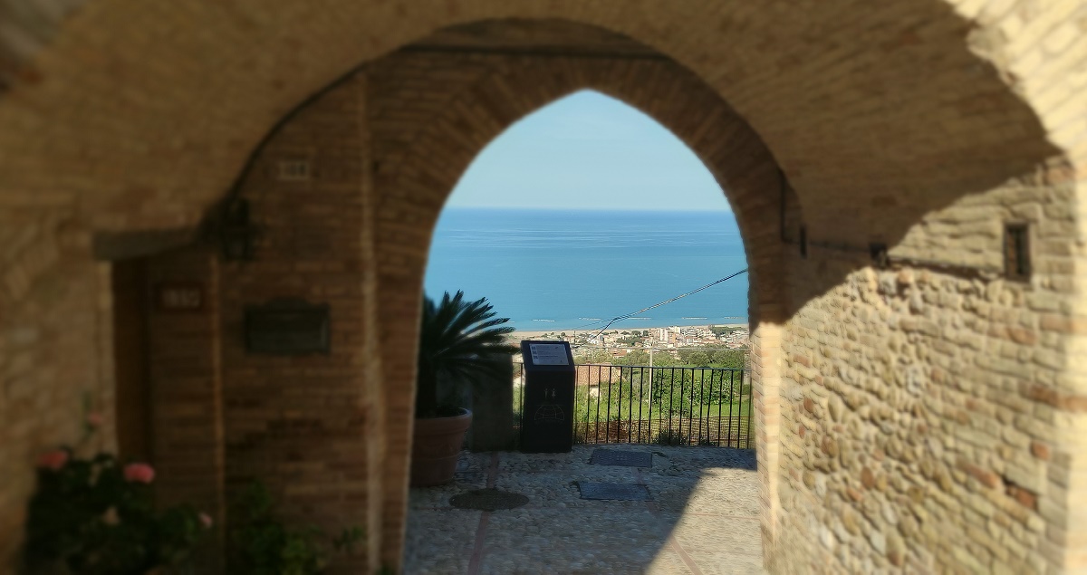 Stone arch in Montepagano with sea in background