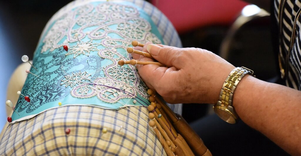 tombolo lace-making showing cushion and hands sewing