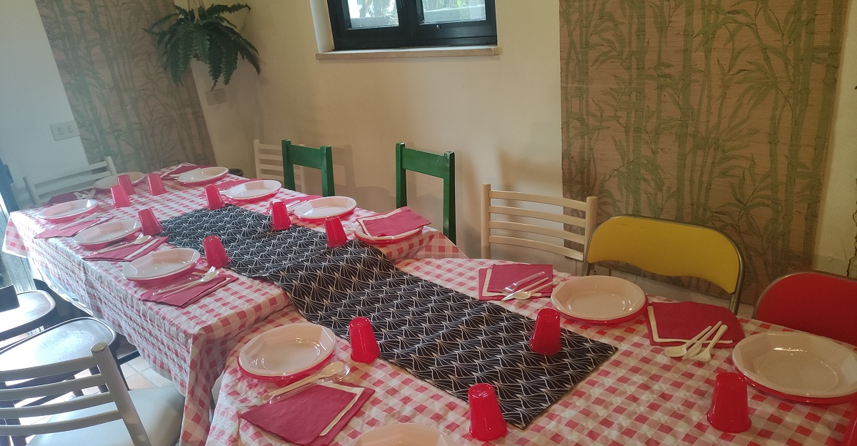 Red and white table setting with chairs all around