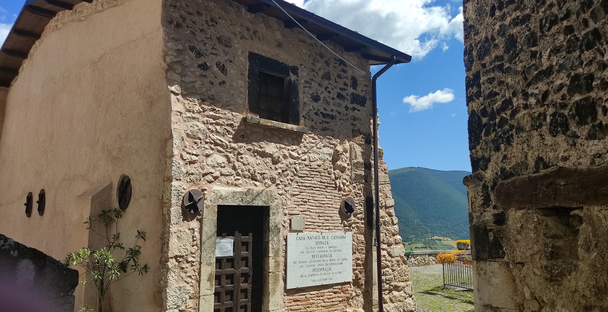 Birthplace of St John - old stone house with mountains in background.