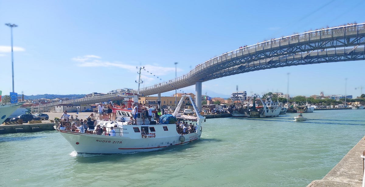 Boat carrying statue of Sant'Andrea leaving port of Pescara, under Ponte del Mare