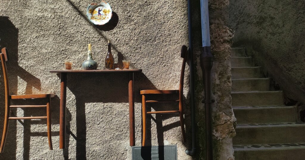 Sculpture, table and chair suspended against wall