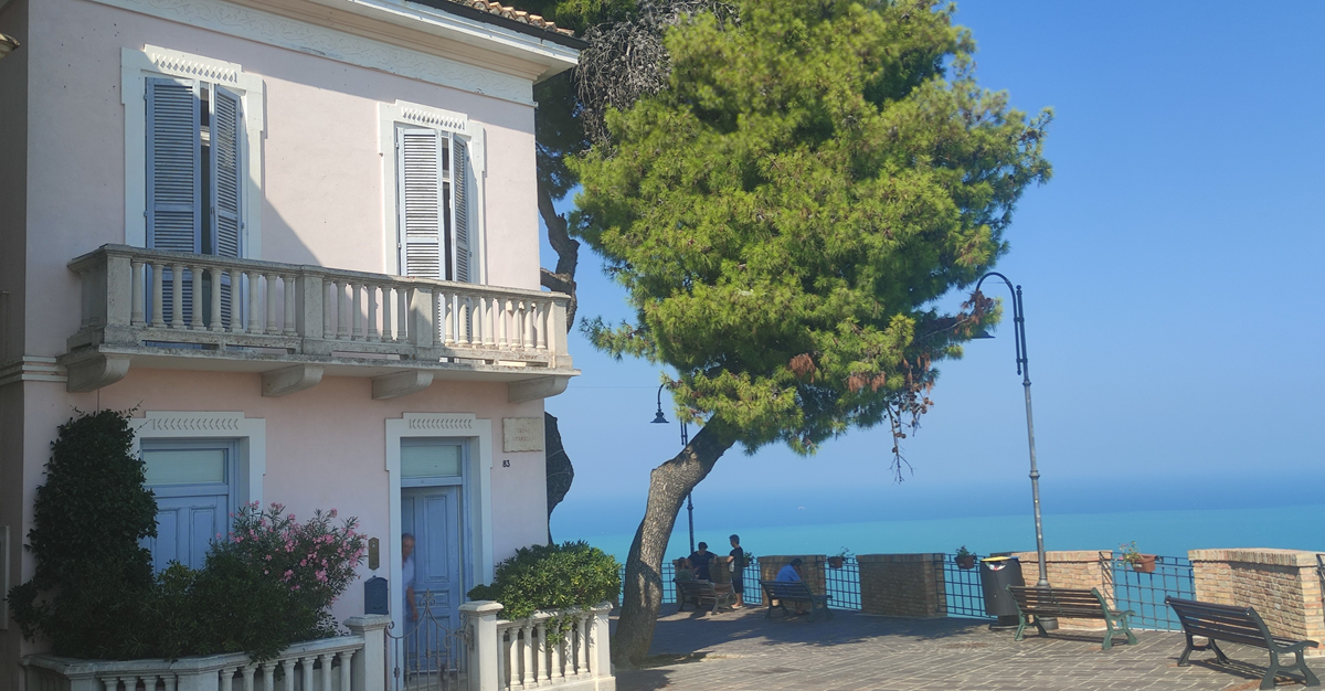 pink house, tree and sea beyond