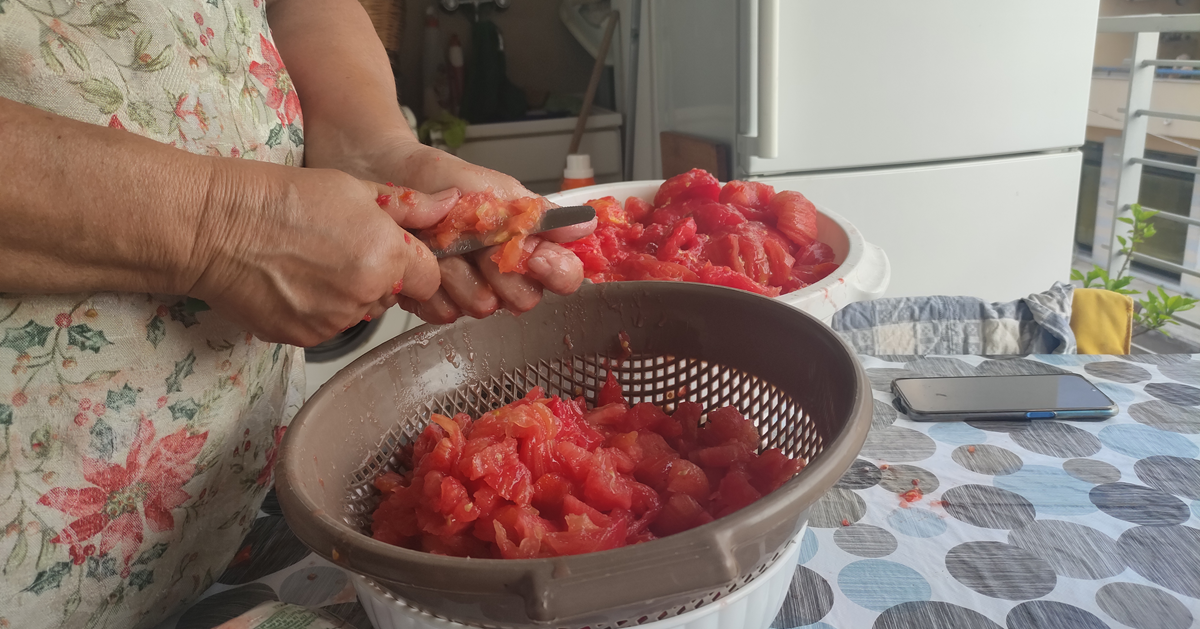 Hands peeling  tomatoes.